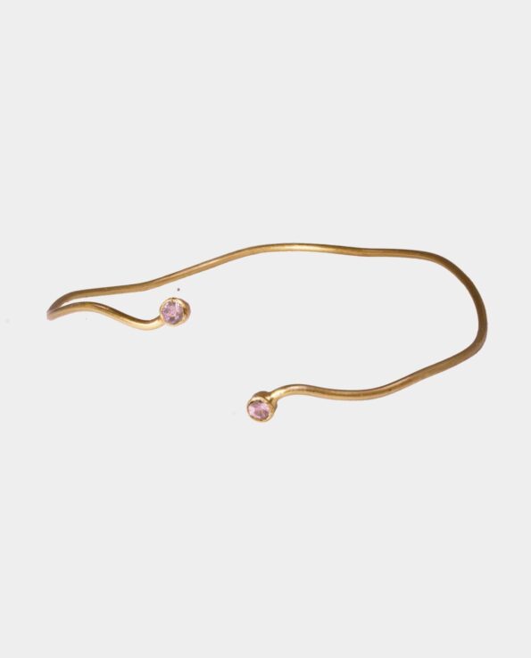 Bracelet with sparkling pink sapphire and sterling silver plated with 18 carat gold that twists around the wrist like a snake