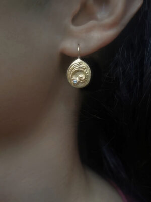 earring with botanical pattern close up