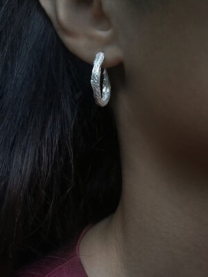 silver hoops with roman pattern close up