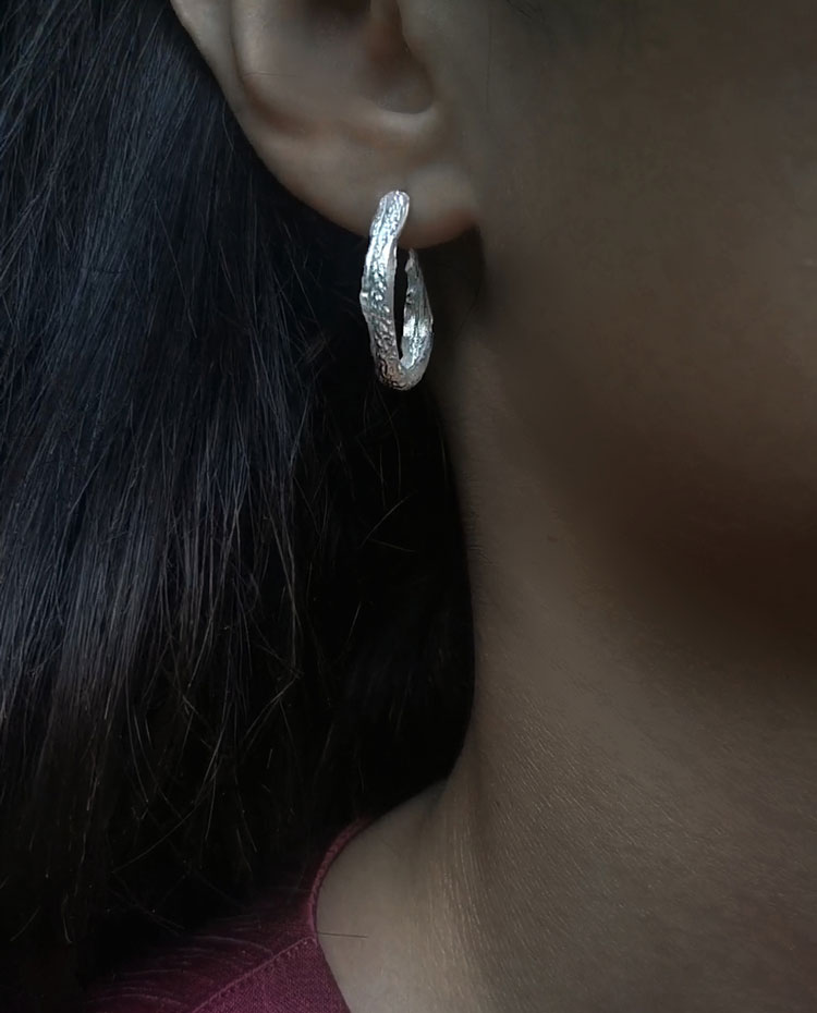 silver hoops with roman pattern close up