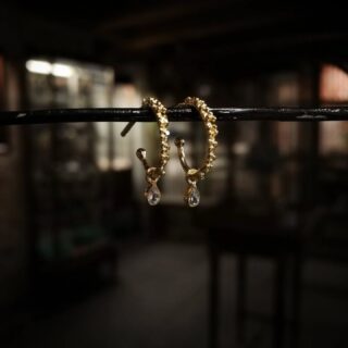 Overfladen på de små kreoler er dækket af tætsiddende knopper, tilfældigt sammensat, som et løfte om forår 🌱
Fra de nuprede grene hænger to skinnende dråber, der har samlet sig som morgendug fra de spæde skud og reflekterer dagens første stråler 🌞.

Find dem i butikken og på webshoppen under navnet "Idun" 🕊️