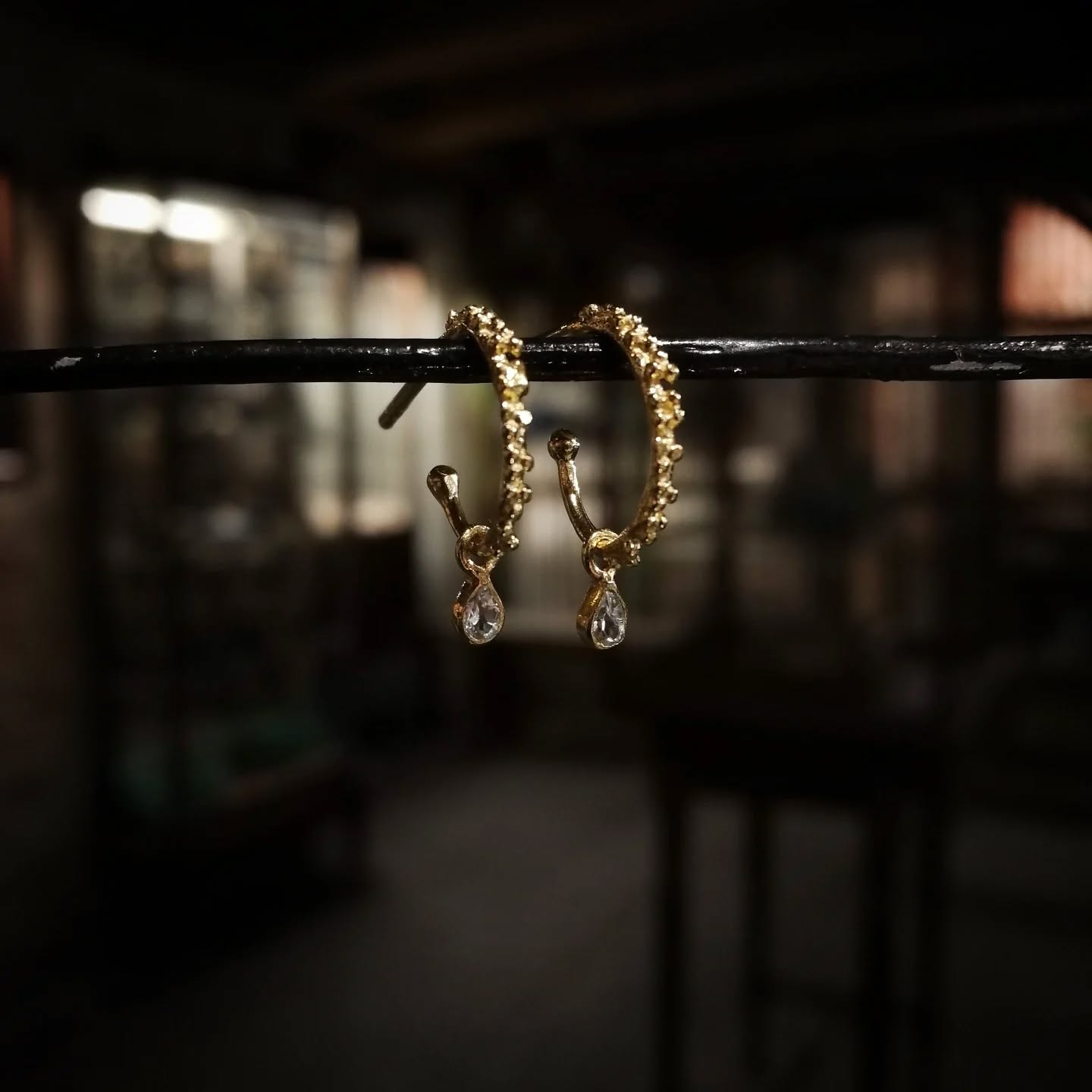 Overfladen på de små kreoler er dækket af tætsiddende knopper, tilfældigt sammensat, som et løfte om forår 🌱
Fra de nuprede grene hænger to skinnende dråber, der har samlet sig som morgendug fra de spæde skud og reflekterer dagens første stråler 🌞.

Find dem i butikken og på webshoppen under navnet "Idun" 🕊️